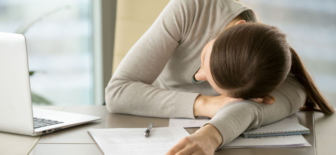Female employee slumbers at workplace in office